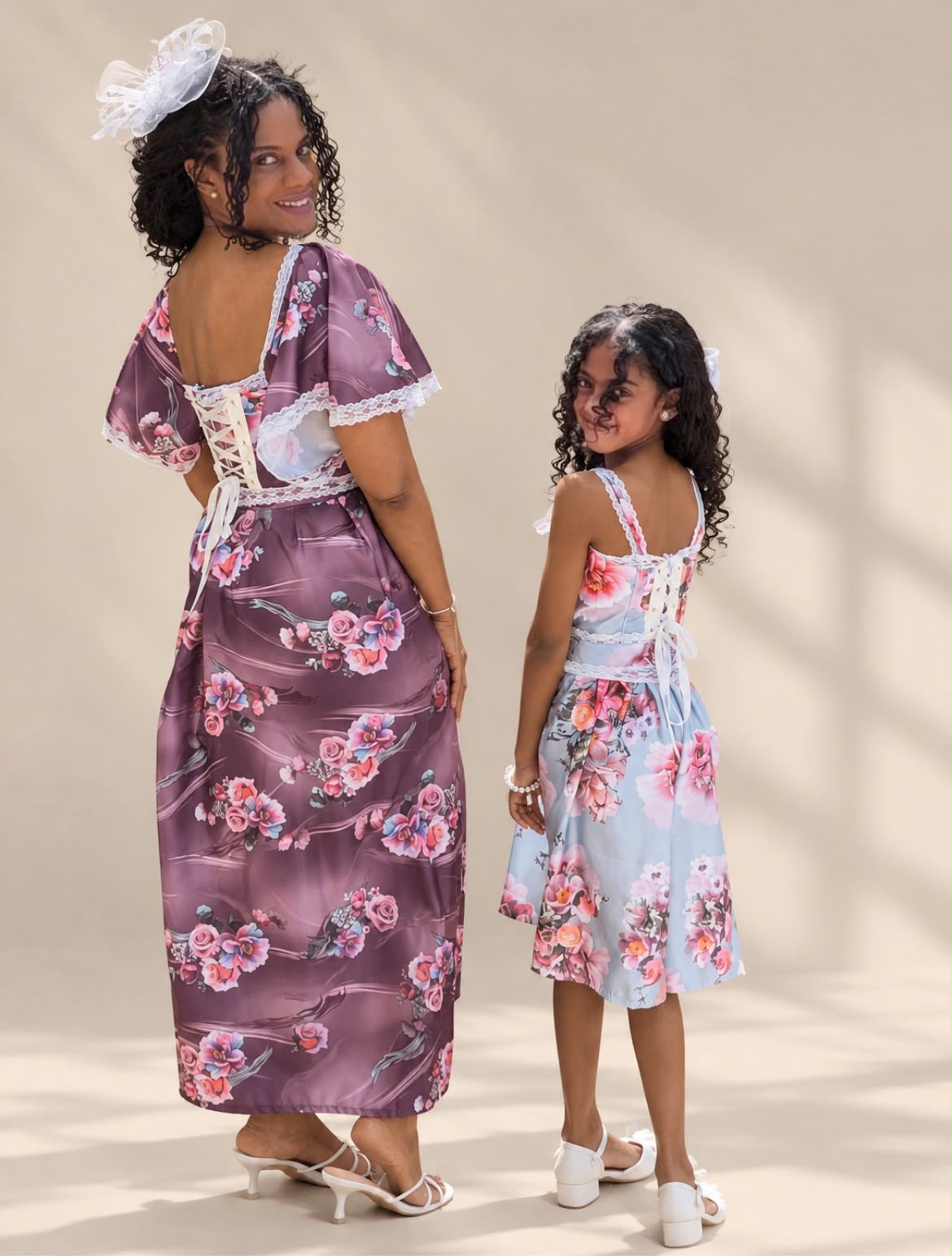 Mother and daughter in matching floral cottage-core dresses with lace-up backs
